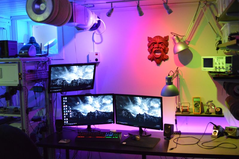 Computer desk with three monitors and RGB lighting