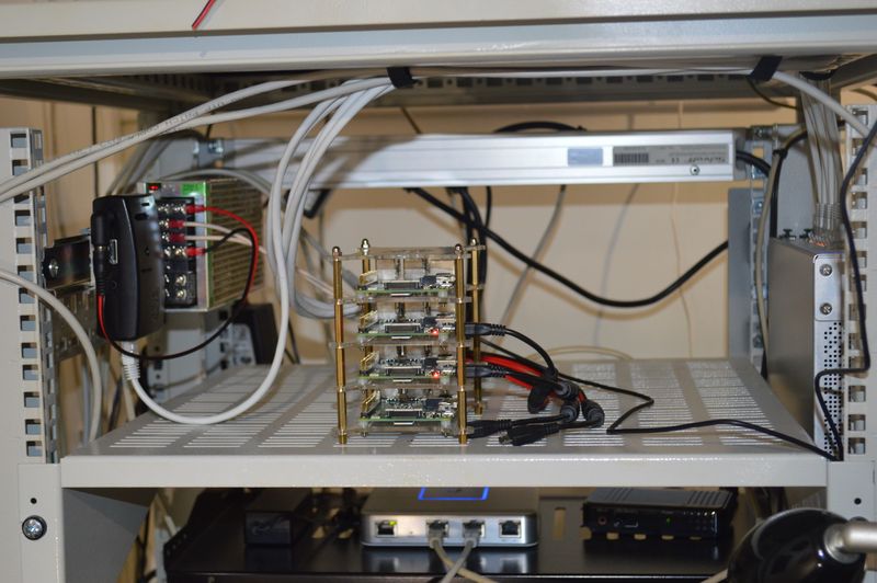 Power supply and five Raspberry Pi boards in homelab rack