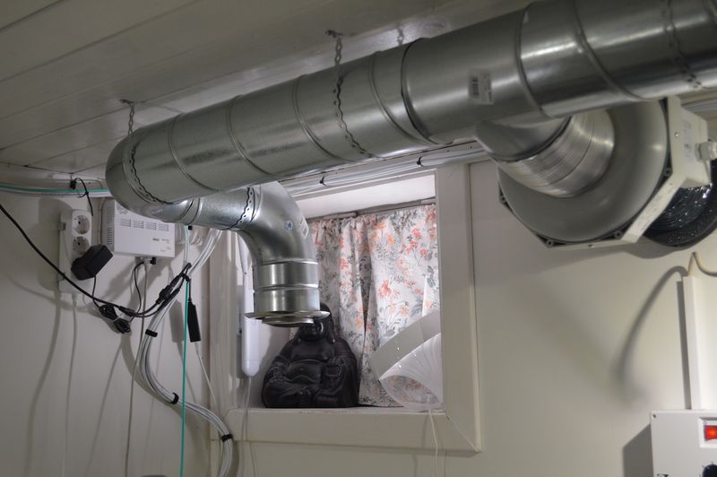 Duct fan connected to T piece spiral duct with air intake, suspended from ceiling