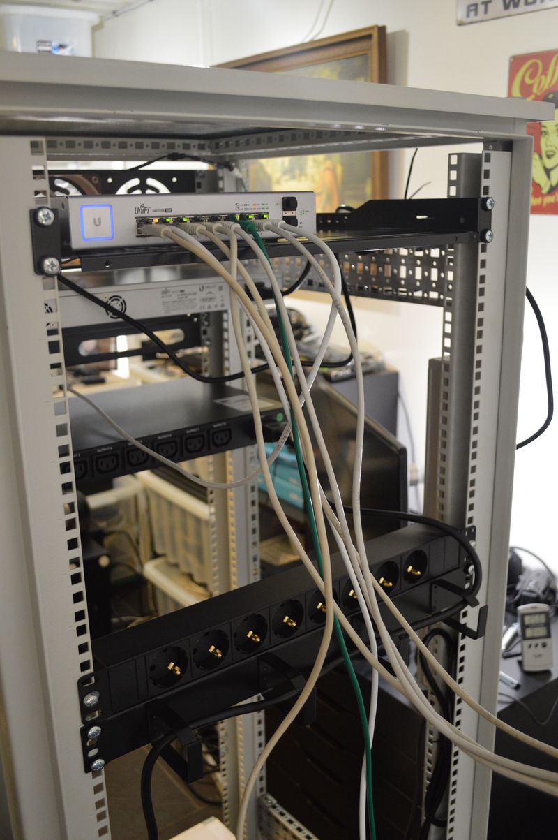 Unifi 8 port PoE switch, with network cables, on rack shelf