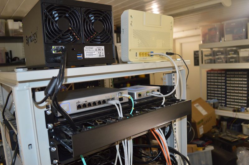 Backside of server rack, with Unifi switch and router, Synology NAS and modem