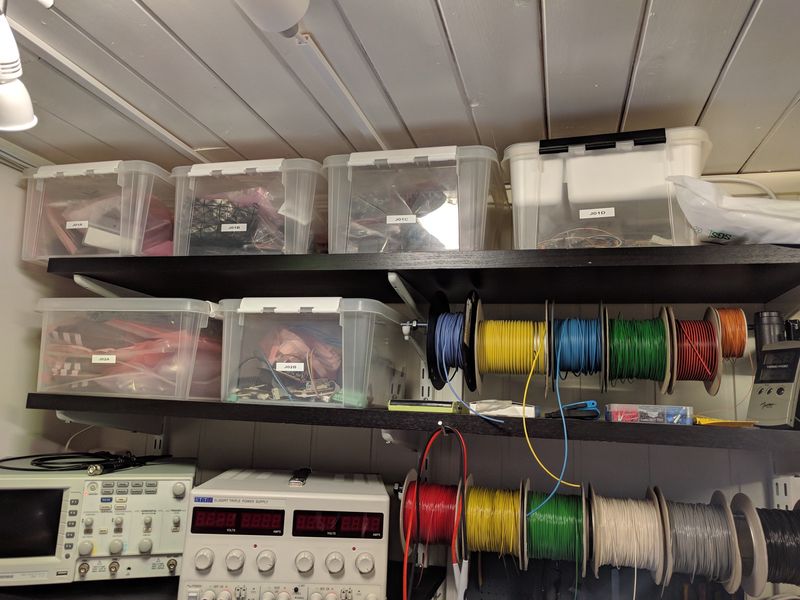 Clear plastic boxes for part storage on shelves, wire spools and instruments