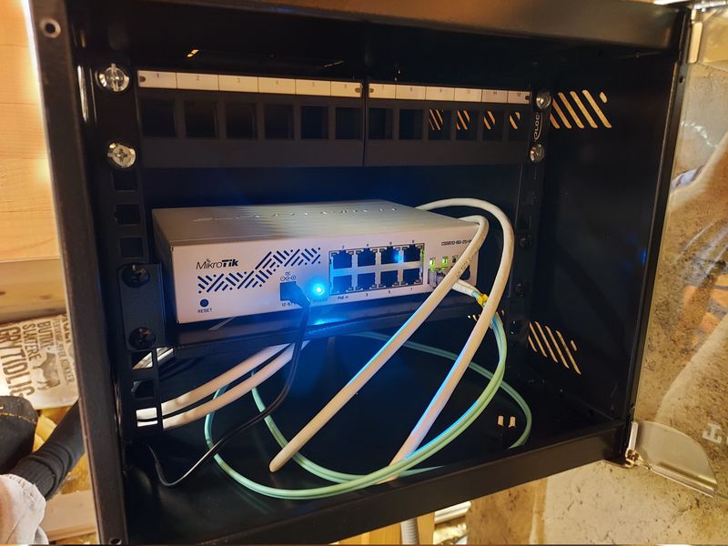 MikroTik CSS610-8G-2S+IN switch in attic wall cabinet